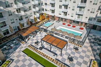 an aerial view of an apartment complex with a pool and patio furniture